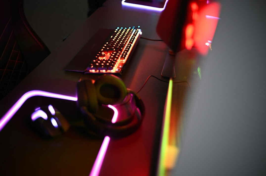 Laptop screen displaying colorful programming code on a desk
