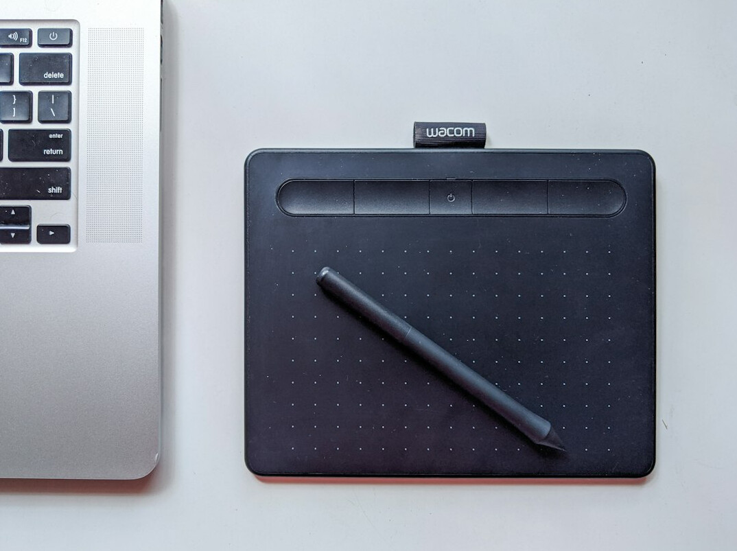 Desk with notebook, pen and laptop showing a flowchart diagram