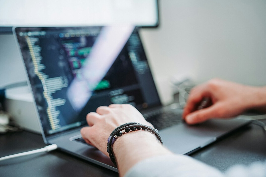 person coding on laptop
