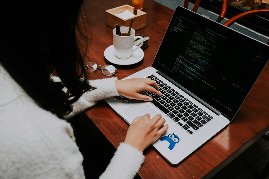 person coding on laptop